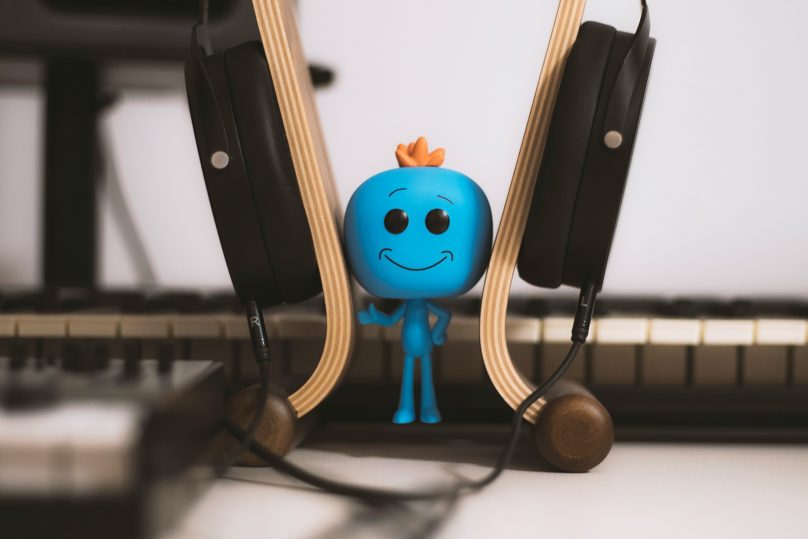 blue male figure wearing headset close-up photography